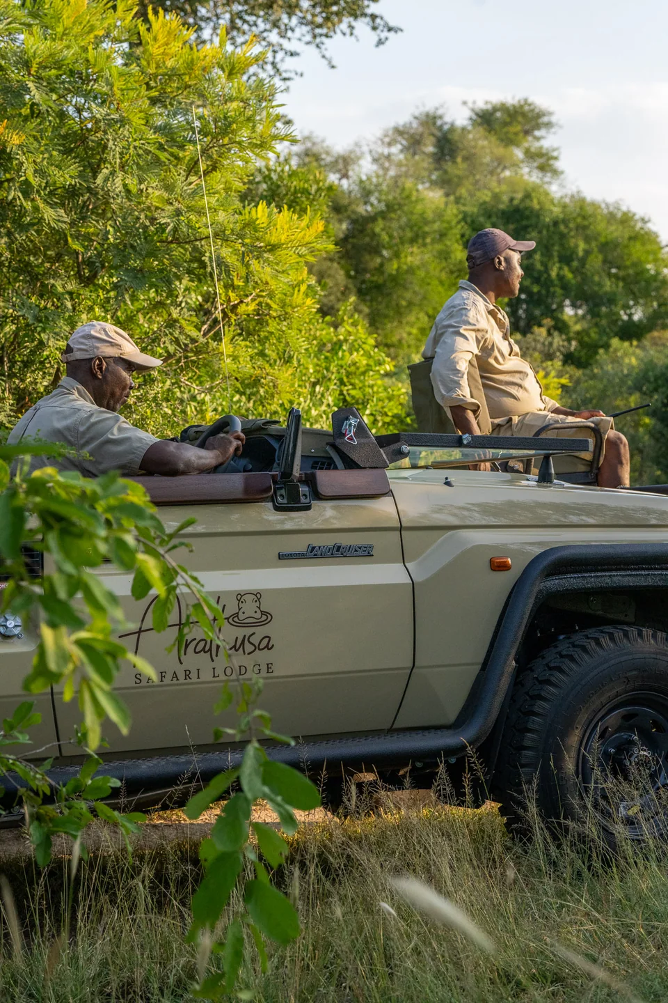 Two safari team members on an Arathusa Safari Lodge vehicle in the bush